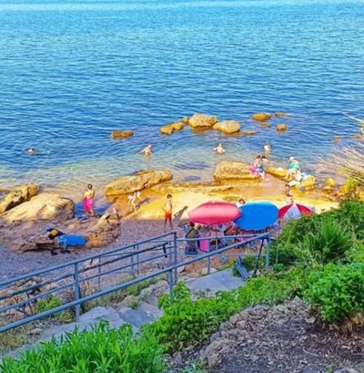Spiaggetta rocciosa con mare turchese e ombrelloni a circa 300 metri dall'appartamento